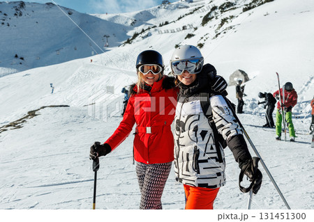 Two young adult happy friends candid portrait enjoy have fun skiing enjoy winter extreme sport activities on sunny day. People winter sport active holidays. Healthy people lifestyle Two young adult happy friends candid portrait enjoy have fun skiing enjoy winter extreme sport activities on sunny day. People winter sport active holidays. Healthy people lifestyle 131451300