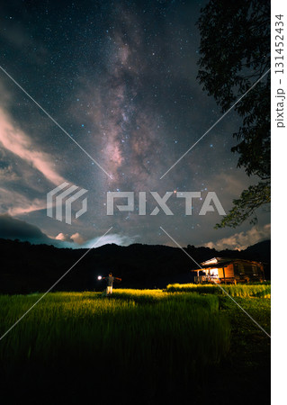 A hut in the middle of a rice field and the belly of a milky way, stars and a night sky with clouds A hut in the middle of a rice field and the belly of a milky way, stars and a night sky with clouds 131452434