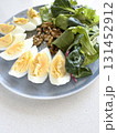 sliced boiled eggs, walnuts, fresh green salad for breakfast 131452912