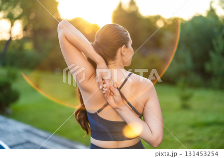 Waist up of a woman stretching her arms while doing yoga Waist up of a woman stretching her arms while doing yoga 131453254