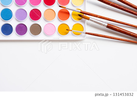 Colorful watercolor palette with brushes on white background 131453832