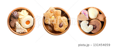 Variety of Christmas cookies and biscuits in wooden bowls. Traditional gingerbread and butter cookies, in different shapes, filled with jam, dipped in chocolate, and topped with nuts or sprinkles. 131454059