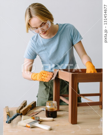 Carpenter sanding wooden furniture in workshop 131454677