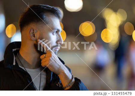 Young man thinking at night city street 131455479