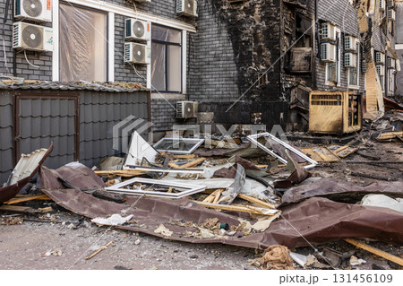 War. The aftermath of Russian airstrikes on a peaceful Ukrainian city. A hospital and a recreation center were destroyed. Charred wall with AC units and debris aftermath of urban fire damage. 131456109
