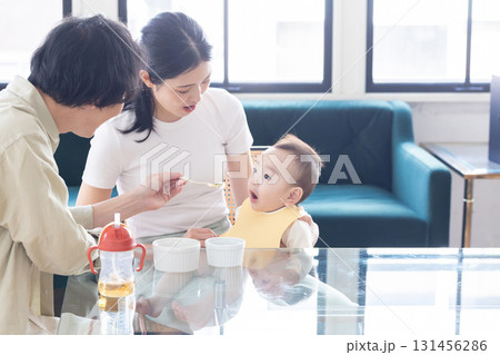 赤ちゃんに離乳食をあげる夫婦 赤ちゃんに離乳食をあげる夫婦 131456286