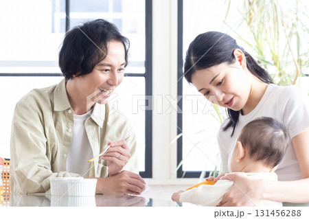 赤ちゃんに離乳食を食べさせる若い夫婦 131456288