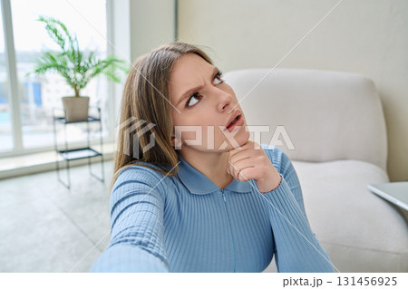 Selfie portrait happy beautiful thinking young woman in home interior Selfie portrait happy beautiful thinking young woman in home interior 131456925