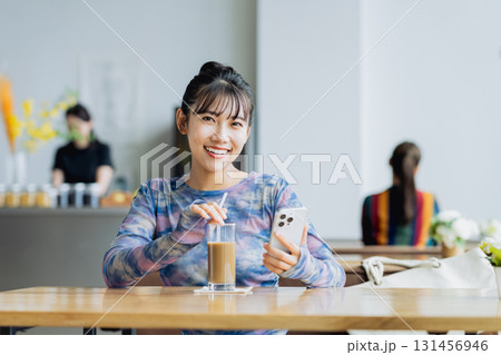カフェでスマホを見る若い女性 カフェでスマホを見る若い女性 131456946