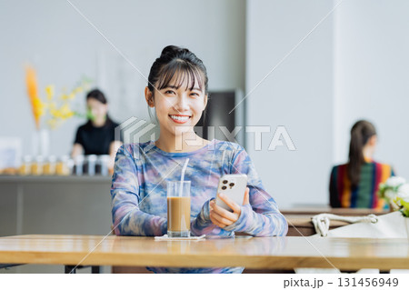 カフェでスマホを見る若い女性 131456949