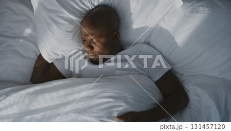 Man Slowly Wakes Up in Bed From Intense Sunlight and Reaches for Smartphone Man Slowly Wakes Up in Bed From Intense Sunlight and Reaches for Smartphone 131457120