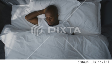 Man Lies in Bed, Stretches, Slowly Wakes Up in Morning Light Man Lies in Bed, Stretches, Slowly Wakes Up in Morning Light 131457121