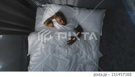 Adult Man Smiles and Stretches in White Bed After Waking Up Adult Man Smiles and Stretches in White Bed After Waking Up 131457168