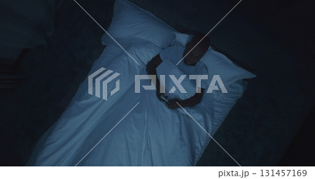 Man in Bed Reads News on Smartphone, While Explosions Outside Window Shake Bedroom 131457169