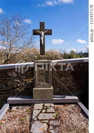 Beautiful Jesus Christ on crucifix, cemetery on a sunny day, spring, Easter, new life and religion concept 131457176