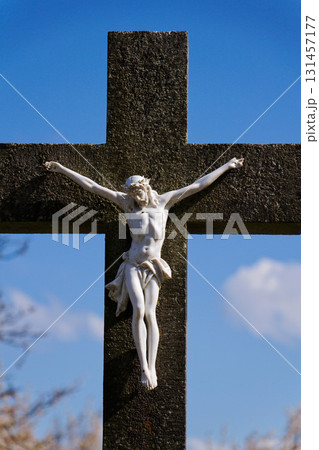 Beautiful Jesus Christ on crucifix, cemetery on a sunny day, spring, Easter, new life and religion concept 131457177