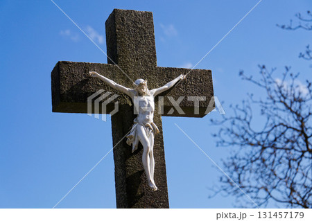 Beautiful Jesus Christ on crucifix, cemetery on a sunny day, spring, Easter, new life and religion concept 131457179