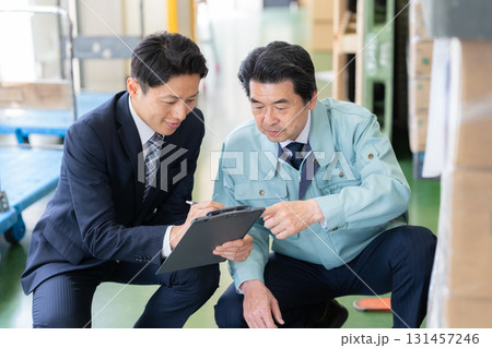 倉庫で商談をする経営者とビジネスマン 倉庫で商談をする経営者とビジネスマン 131457246