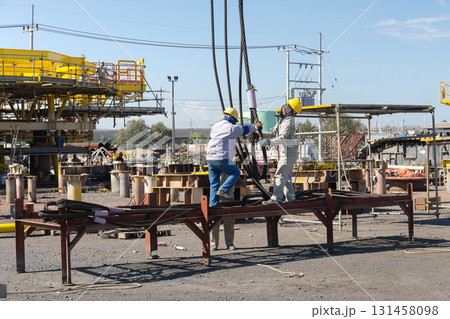 Industrial workers with cables sling. 131458098