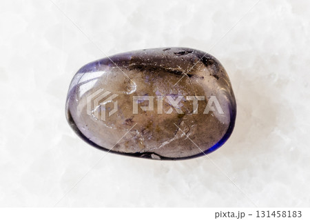 sample of tumbled iolite mineral on white marble 131458183