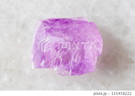 sample of rough kunzite crystal on white marble 131458222