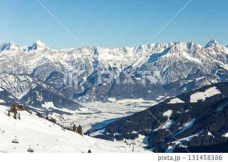 Scenic Saalbach-Hinterglemm-Leogang skicircus area snow-covered alpine mountains horizon sharp peaks illuminated sunlight. Valley forests ski slopes, chairlifts winter holiday activities white slopes 131458386