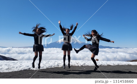 富士山を背景にセーラー服姿のアジア人女性3人がポーズを決めるシンクロ写真 131458660