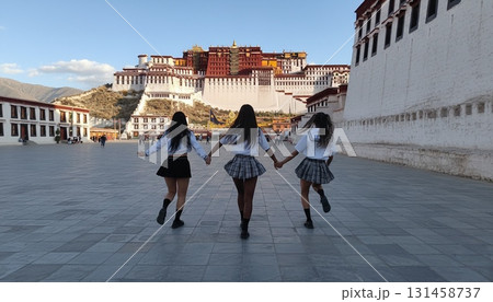 チベットのポタラ宮を背景にセーラー服姿のアジア人女性3人がポーズを決めるシンクロ写真 131458737
