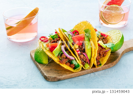 Tacos on a wooden board and Paloma cocktails, Mexican food and drink Tacos on a wooden board and Paloma cocktails, Mexican food and drink 131459043