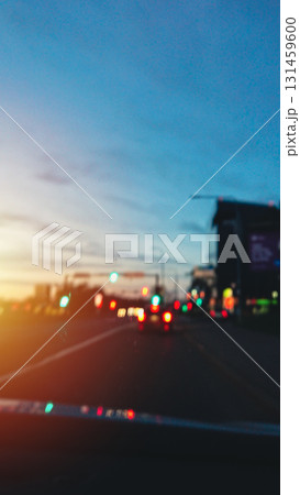 City driving at blue hour on main avenue in urban flow, blurred bokeh, vertical 131459600
