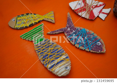 Make a cardboard fish using thread and paint, with detailed instructions, on an orange backdrop. Make a cardboard fish using thread and paint, with detailed instructions, on an orange backdrop. 131459695