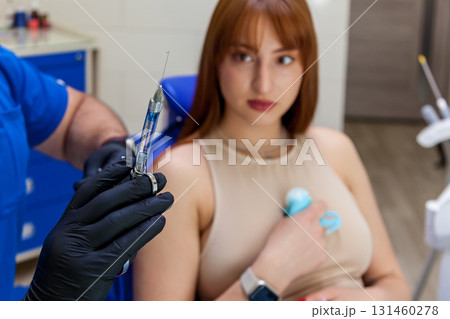 Dentist preparing injection for young woman during dental procedure 131460278