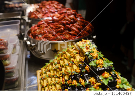 Delicious seafood and colorful desserts arranged at a bustling street food market in the evening in Mexico with vendors serving local delicacies to eager customers 131460457