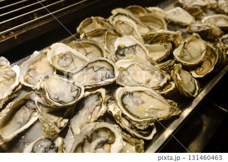 Freshly shucked oysters on a silver platter during a seafood feast at a coastal restaurant in a vibrant seaside town in early summer Freshly shucked oysters on a silver platter during a seafood feast at a coastal restaurant in a vibrant seaside town in early summer 131460463