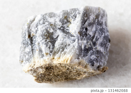sample of raw melilite mineral on white marble 131462088