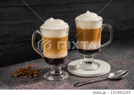 Layered coffee latte drinks. Hot coffee drinks in glass mugs, dark background 131462293