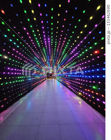 A stunning tunnel is illuminated by thousands of colorful LED lights, creating a mesmerizing and vibrant archway that leads into a distant, brightly lit building. A stunning tunnel is illuminated by thousands of colorful LED lights, creating a mesmerizing and vibrant archway that leads into a distant, brightly lit building. 131462690