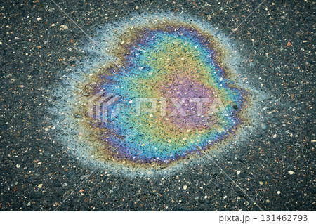 Oil slick on wet asphalt showing abstract iridescence and rainbow colors. Oil slick on wet asphalt showing abstract iridescence and rainbow colors. 131462793