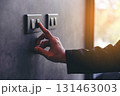 The young man's hand turned off the light switch. Energy saving concept. Hand Turning Off Light Switch. Saving Electricity with a Single Action. 131463003