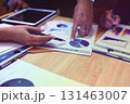 A group of business people are meeting to analyze data for marketing plan 131463007