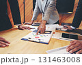 A group of business people are meeting to analyze data for marketing plan 131463008