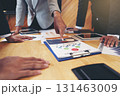 A group of business people are meeting to analyze data for marketing plan 131463009