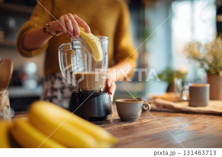 Woman making popular banana coffee drink in calm domestic setting 131463713
