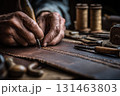 Craftsman stitching leather by hand close-up 131463803