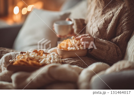 Cozy living room scene, person snacking on comfort salty snacks 131464017