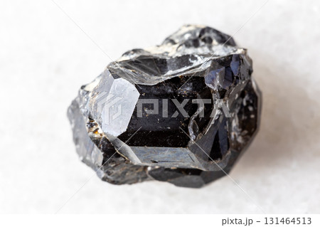 sample of rough black andradite garnet on white 131464513