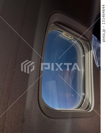 Serene airplane window view reveals a vast clear blue sky, symbolizing travel, journey, freedom, and the peaceful experience of aerial flight 131464644