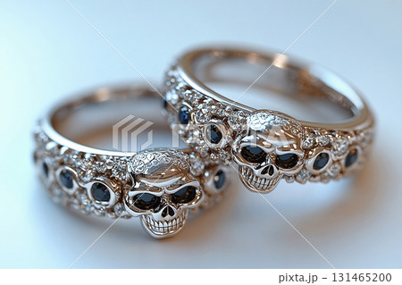 Pair of gold wedding rings with a skull pattern on a white background. Original style. 131465200