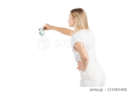 Studio portrait of woman with magnifying glass 131465408