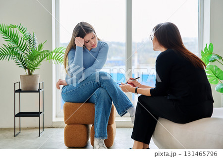 Young woman in a therapy session talking with a psychotherapist Young woman in a therapy session talking with a psychotherapist 131465796